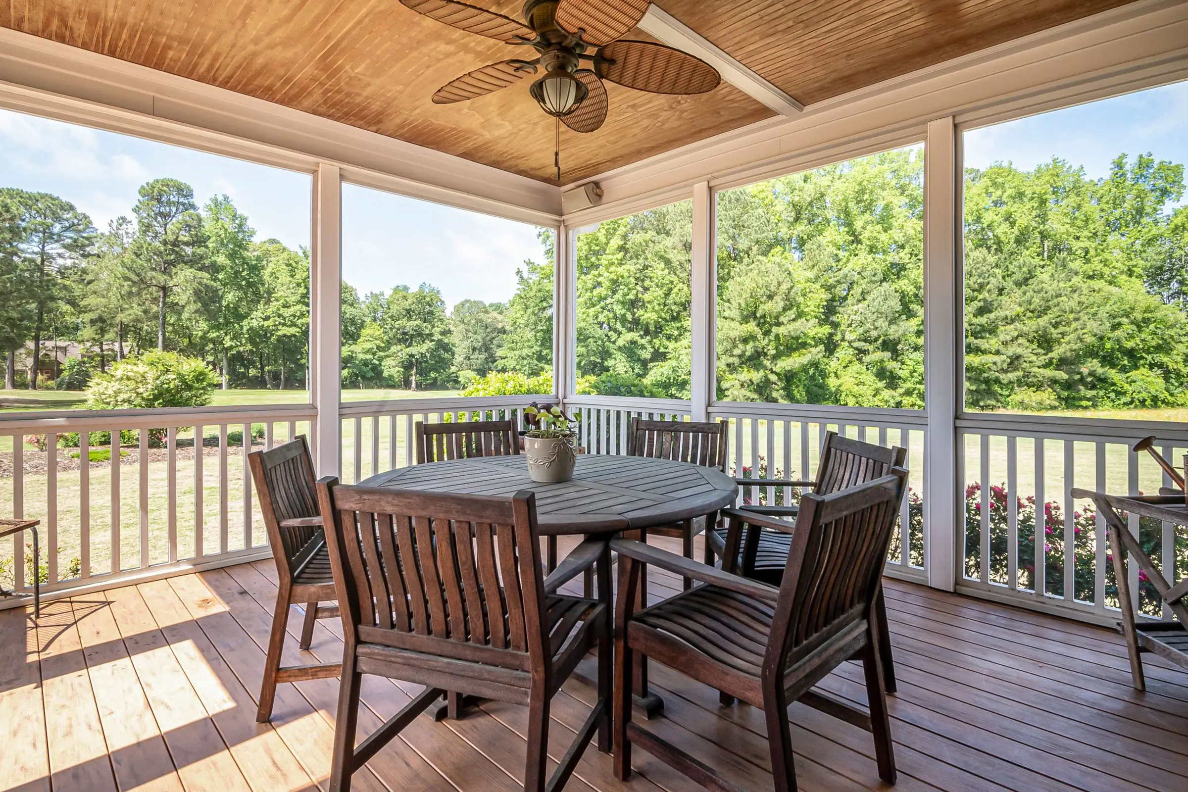 Covered porch with a wood ceiling, ceiling fan and dining table
